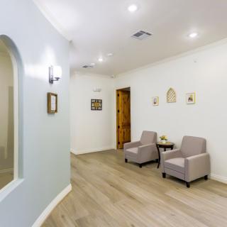 A modern and minimalist waiting area with comfortable chairs, soft lighting, and tasteful decor.