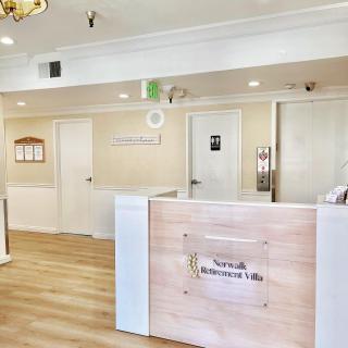 A modern reception area with a wooden desk and bright lighting.