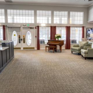 A spacious lobby with a piano and seating area.