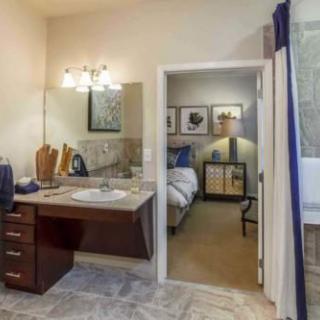 A view from a bathroom into an adjacent bedroom, showcasing interior design elements like a sink area and stylish decor.
