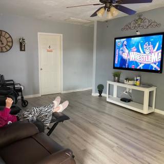 A cozy living room with a person relaxing on the sofa, watching TV.