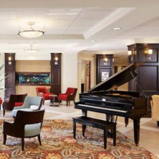 A spacious lobby with a grand piano and comfortable seating.