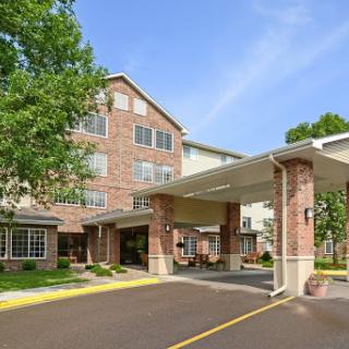A view of the entrance to a hotel, featuring modern architecture and landscaped surroundings.