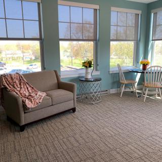 Bright and cozy living space with a sofa, dining area, and large windows.