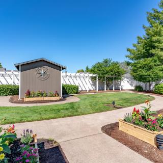 A beautifully landscaped garden with a path and vibrant flowers under a clear blue sky.
