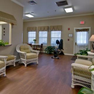 A cozy waiting room with wicker furniture and green plants.