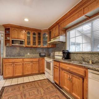 A spacious kitchen with wooden cabinets and modern appliances.