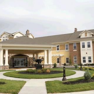 A well-maintained residential building with a landscaped entrance and driveway.
