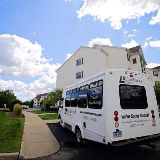 A shuttle bus parked in a residential area under a cloudy sky.