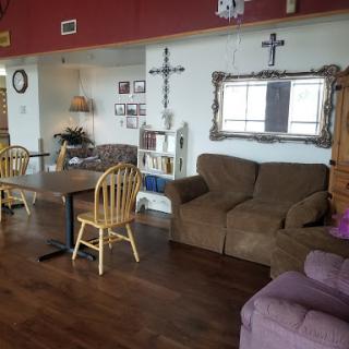 A cozy living room featuring a sofa, dining table, and various decorations.