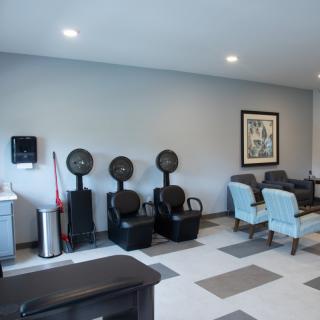 A modern salon interior featuring hair dryers and a comfortable seating area.