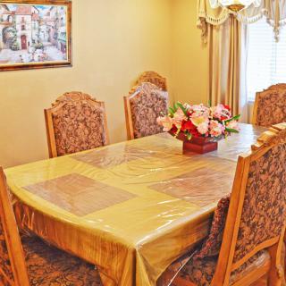 A dining room with a table set for six, featuring a floral centerpiece and elegant decor.