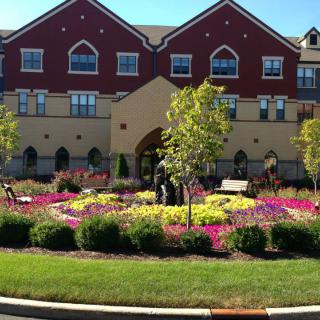 A beautifully landscaped garden in front of a large brick building.