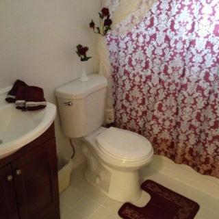 A cozy bathroom with a floral shower curtain and matching decor.