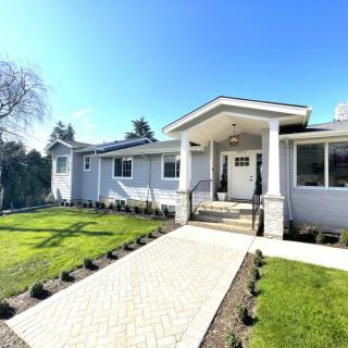 A modern single-story house with a well-maintained front yard on a sunny day.