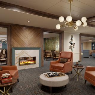 A modern and cozy lobby featuring a fireplace, comfortable seating, and a stylish chandelier.