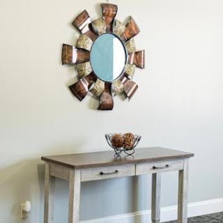 A stylish console table adorned with a decorative mirror and bowl, perfect for enhancing any entryway.