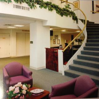A lobby area with comfortable seating and a spiral staircase.