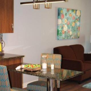 A cozy dining area featuring a sleek table, comfortable chairs, and vibrant artwork.
