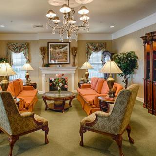 A traditional living room with elegant furnishings and a central chandelier.