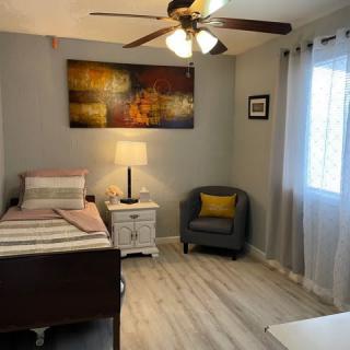 A cozy bedroom with a single bed, armchair, and stylish artwork on the wall.