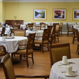 Empty dining room with tables and chairs set for service.