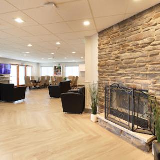 A cozy lounge area featuring a stone fireplace and modern seating, perfect for relaxation.
