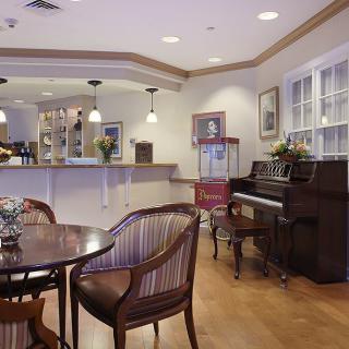 A cozy cafe interior featuring a piano and wooden seating area.