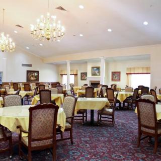 Elegantly set dining room with chandeliers and neatly arranged tables.
