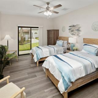 A cozy, modern bedroom with twin beds and ample natural light.
