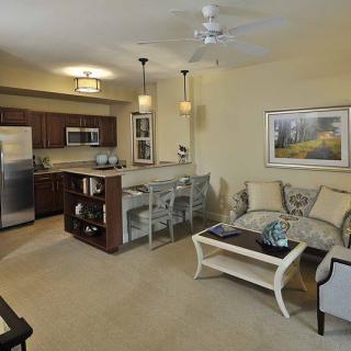 A modern apartment with an open floor plan featuring a living room and kitchen area.