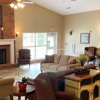 A cozy and bright living room with a fireplace, sofas, and chairs arranged for comfort.