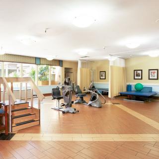 A bright and spacious gym with various exercise equipment, including treadmills and a set of stairs for workouts.
