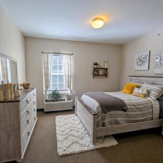 A modern and cozy bedroom with a neatly made bed, decorative pillows, and stylish wall art.