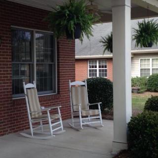 A cozy front porch with rocking chairs and hanging ferns.