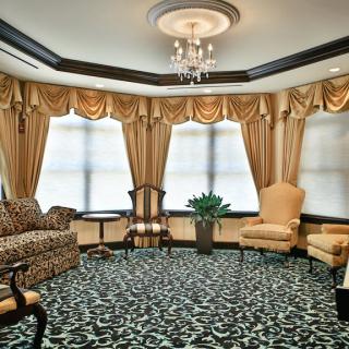 A traditionally decorated living room with elegant furnishings and a central chandelier.