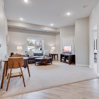 A modern living room with a comfortable sofa, television, and ample lighting.