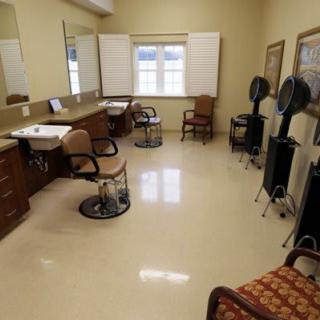 A spacious salon with chairs and hair dryers arranged neatly.