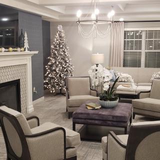 A cozy living room with modern decor, featuring a decorated Christmas tree by the fireplace.
