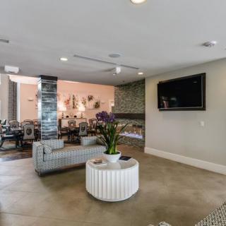 A modern living room with a stylish seating area, flat-screen TV, and elegant decor.