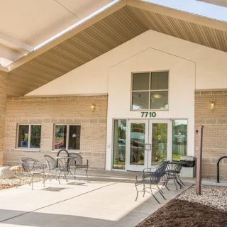 An exterior view of a building with a patio and outdoor seating area.