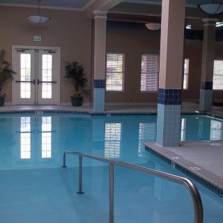 An indoor swimming pool with clear blue water and elegant columns.