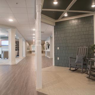 A modern lobby featuring a green accent wall and comfortable rocking chairs.