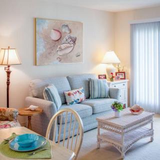 A cozy and well-decorated living room featuring a comfortable sofa, stylish coffee table, and warm lighting from lamps.