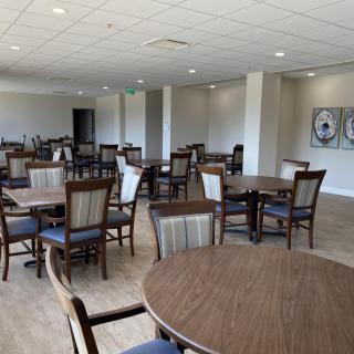 A spacious dining area with multiple tables and chairs arranged neatly.