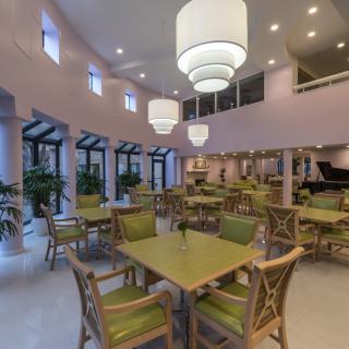 A modern restaurant interior featuring spacious dining area with stylish tables, chairs, and ambient lighting.