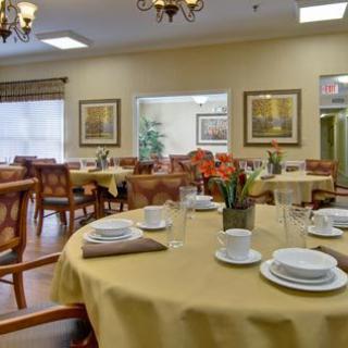 A cozy dining room with elegantly set tables and chairs, ready for guests.
