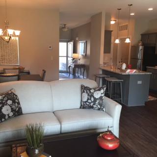 A modern open floor plan with a cozy living room leading into a kitchen and dining area.