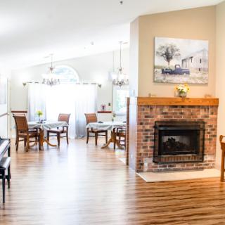 A bright and inviting open-concept living and dining area featuring a cozy fireplace and elegant furnishings.