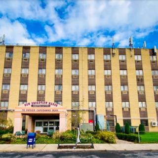 A view of the hospital building with a clear blue sky and scattered clouds.